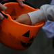 Hands Picking Candy From Halloween Basket